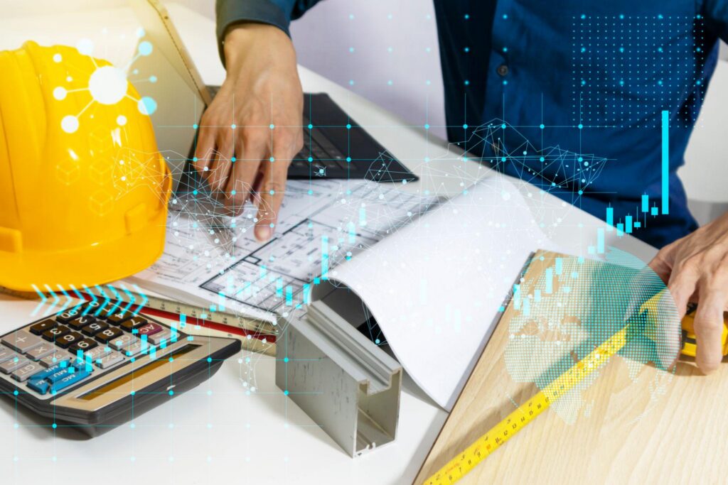 Man seated at desk handling Hydraulic system design plans at TAP Hydraulic Consulting office